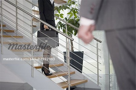 Homme d'affaires remontant à la femme d'affaires sur l'escalier