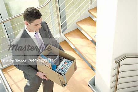 Kaufmann auf Büro-Treppe mit Box von Gegenständen