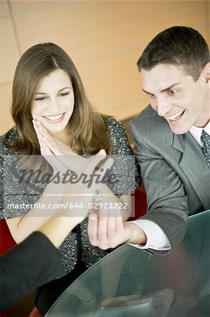 Couple receiving keys from female hand