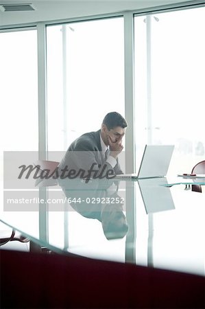 Businessman at laptop computer with his face in his hand