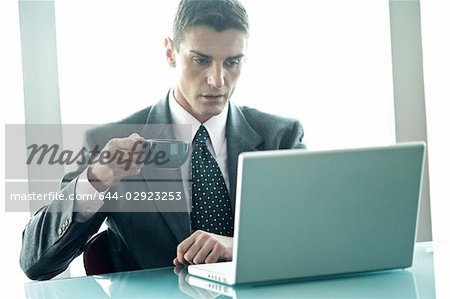 Businessman at laptop computer with coffee cup