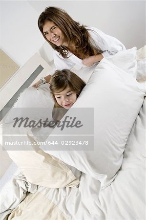 Junge Frau und Mädchen auf dem Bett zu spielen