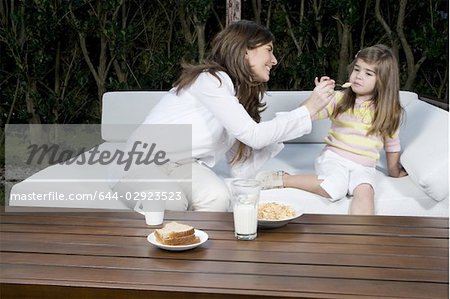 Jeune femme et fillette avec petit déjeuner à l'extérieur