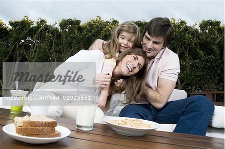 Junges Paar und Mädchen frühstücken im freien