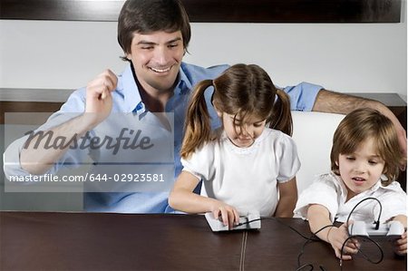 Young man with children playing video game