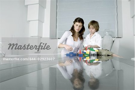 Junge Frau und Knabe mit Bausteinen zu spielen