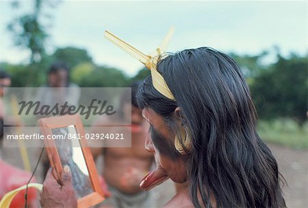 Suya Indian admiring lip disk in mirror, Brazil, South America (1971)