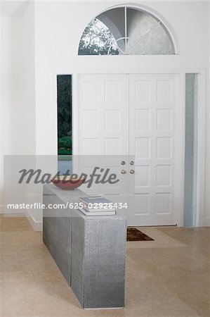 Stack of books and decorative urn on the ledge in a room