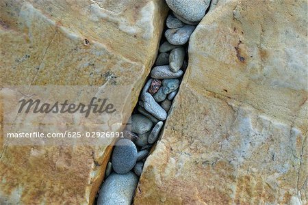 High angle view of pebbles in a gap of rocks