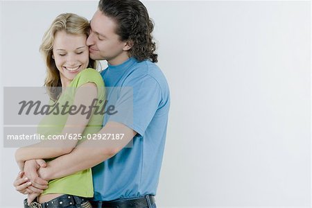 Seitenansicht eines jungen Mannes, der eine junge Frau küssen
