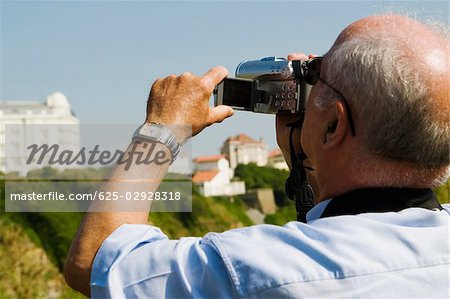 Vue arrière d'un homme filmer avec sa caméra vidéo, Biarritz, Pays Basque, Pyrénées-Atlantiques, Aquitaine, France