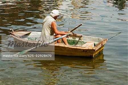 Rear view of a man sitting in a boat, Marina Grande, Capri, Sorrento, Sorrentine Peninsula, Naples Province, Campania, Italy