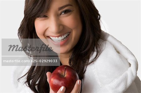 Porträt einer jungen Frau hält einen Apfel und Lächeln