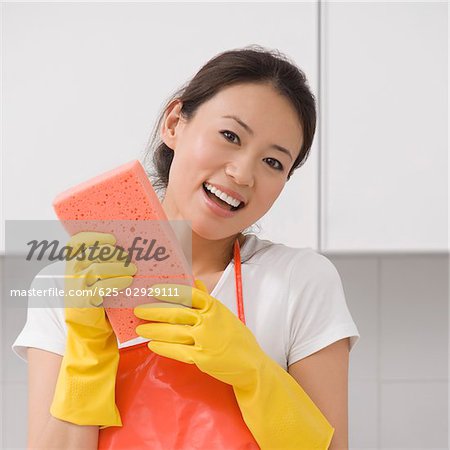 Portrait d'une jeune femme tenant une éponge de bain et souriant