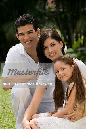 Portrait d'un jeune couple avec leur fille dans un parc