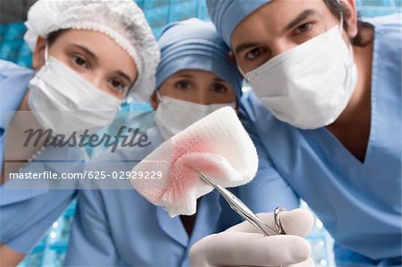 Deux chirurgiens femelles et un mâle chirurgien en salle d'opération