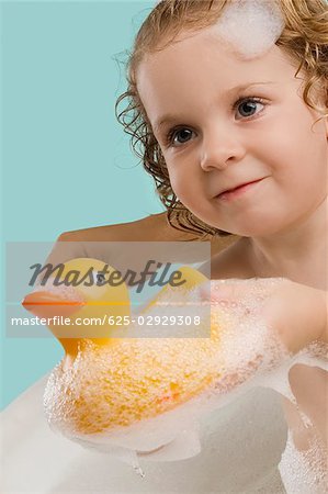 Close-up of a girl holding a rubber duck and smiling