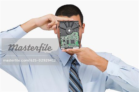 Close-up of a businessman holding a hard drive in front of his face
