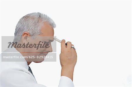 Side profile of a businessman holding a pen and thinking