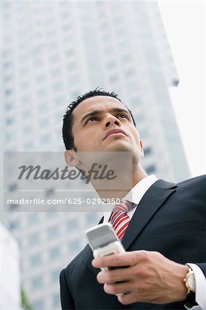 Low angle view of a businessman holding a mobile phone