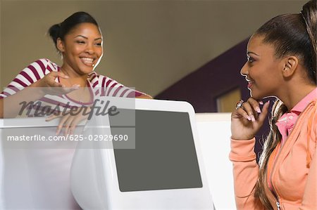 Two young women looking at each other and smiling