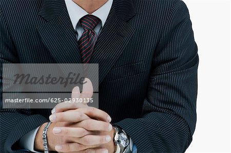 Mid section view of a businessman with his hands clasped