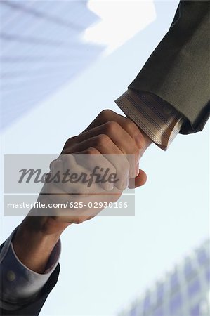 Low angle view of two people shaking hands