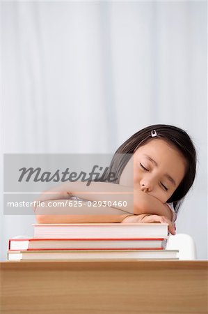 Écolière dormir à un bureau dans une salle de classe