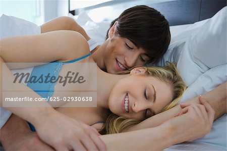 Jeune couple romancing sur le lit