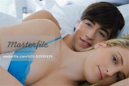 Portrait of a young couple lying on the bed