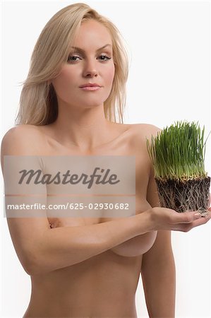 Portrait of a young woman holding wheatgrass