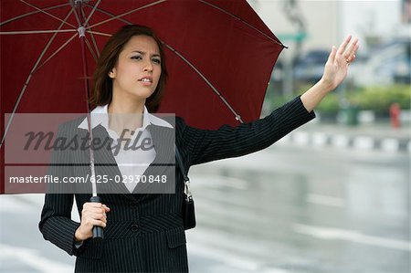 Close-up of a businesswoman hailing for a vehicle