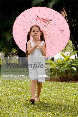 Girl walking in a park with an umbrella