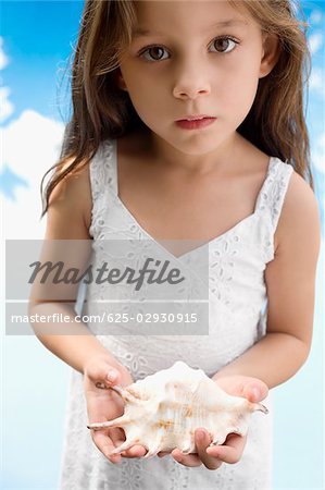 Portrait of a girl holding a seashell
