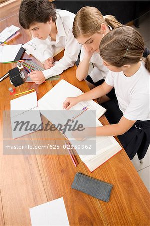 Vue grand angle deux écolières et un écolier étudier dans une salle de classe