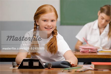 Schülerin in einem Klassenzimmer sitzen und Lächeln