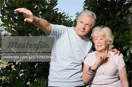 Debout de couple senior dans un jardin