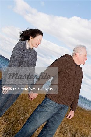 Couple debout sur la plage avec la main dans la main de l'autre