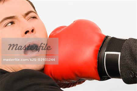Close-up of a person's hand punching a businessman