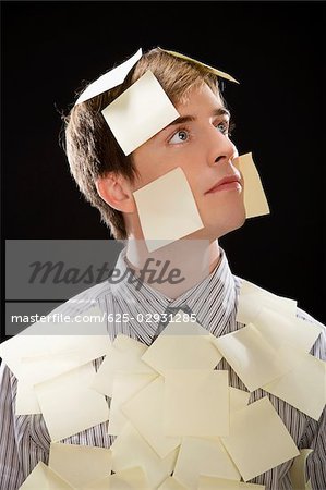 Businessman covering with adhesive notes and thinking