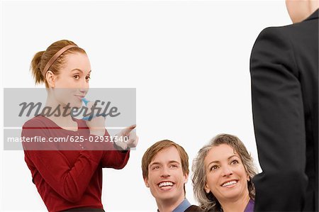 Businesswoman blowing whistle with three business executives beside her