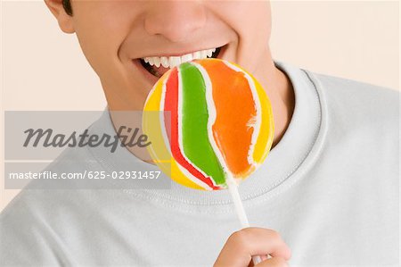 Close-up of a young man licking a lollipop