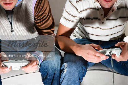 Close-up of two young men playing video game