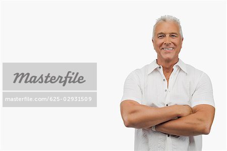 Portrait d'un homme senior debout avec les bras croisés et souriant