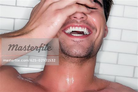 Close-up of a young man bathing and laughing