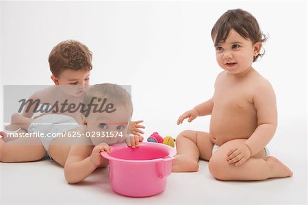 Close-up of two baby boys and a boy playing together