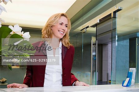 Businesswoman standing at the hotel reception and smiling