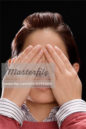 Close-up of a businesswoman covering her eyes with her hands
