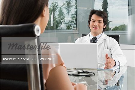 Male doctor talking to a woman in a clinic