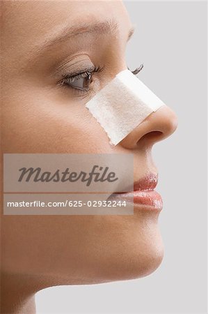 Gros plan d'une patiente avec un pansement adhésif sur son nez